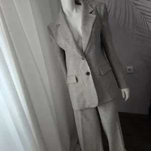 Elegantan ZARA komplet u nijansi svetli pesak, savršen za poslovne i svečanije prilike