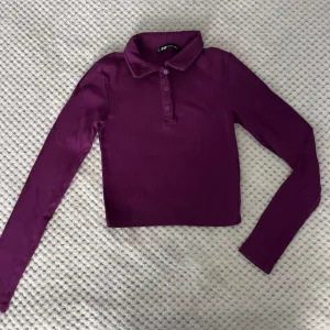 Ljubičasta crop top majica sa kragnom