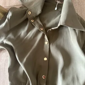 Mona kosulja iz jesenje kolekcije sa zlatnim detaljima