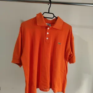 LACOSTE NARANDŽASTA MAJICA SA KRAGNICOM