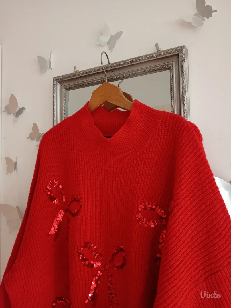 Crveni džemper sa mašnama po sebi