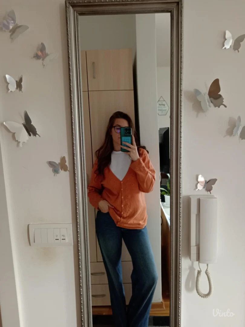 Narandžasti džemper sa radom po sebi