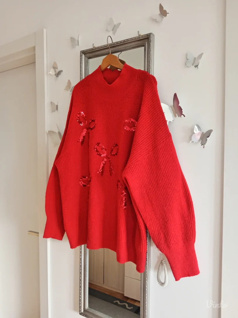 Crveni džemper sa mašnama po sebi