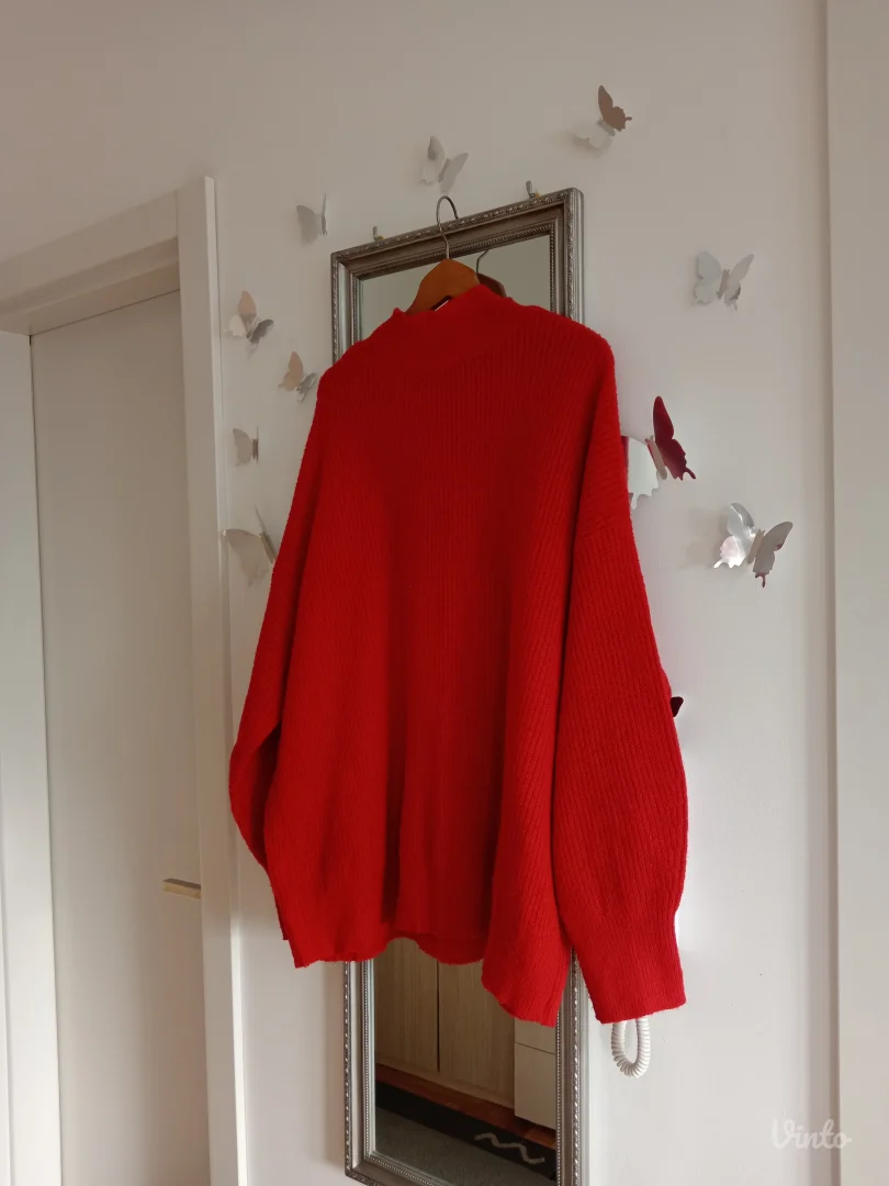 Crveni džemper sa mašnama po sebi