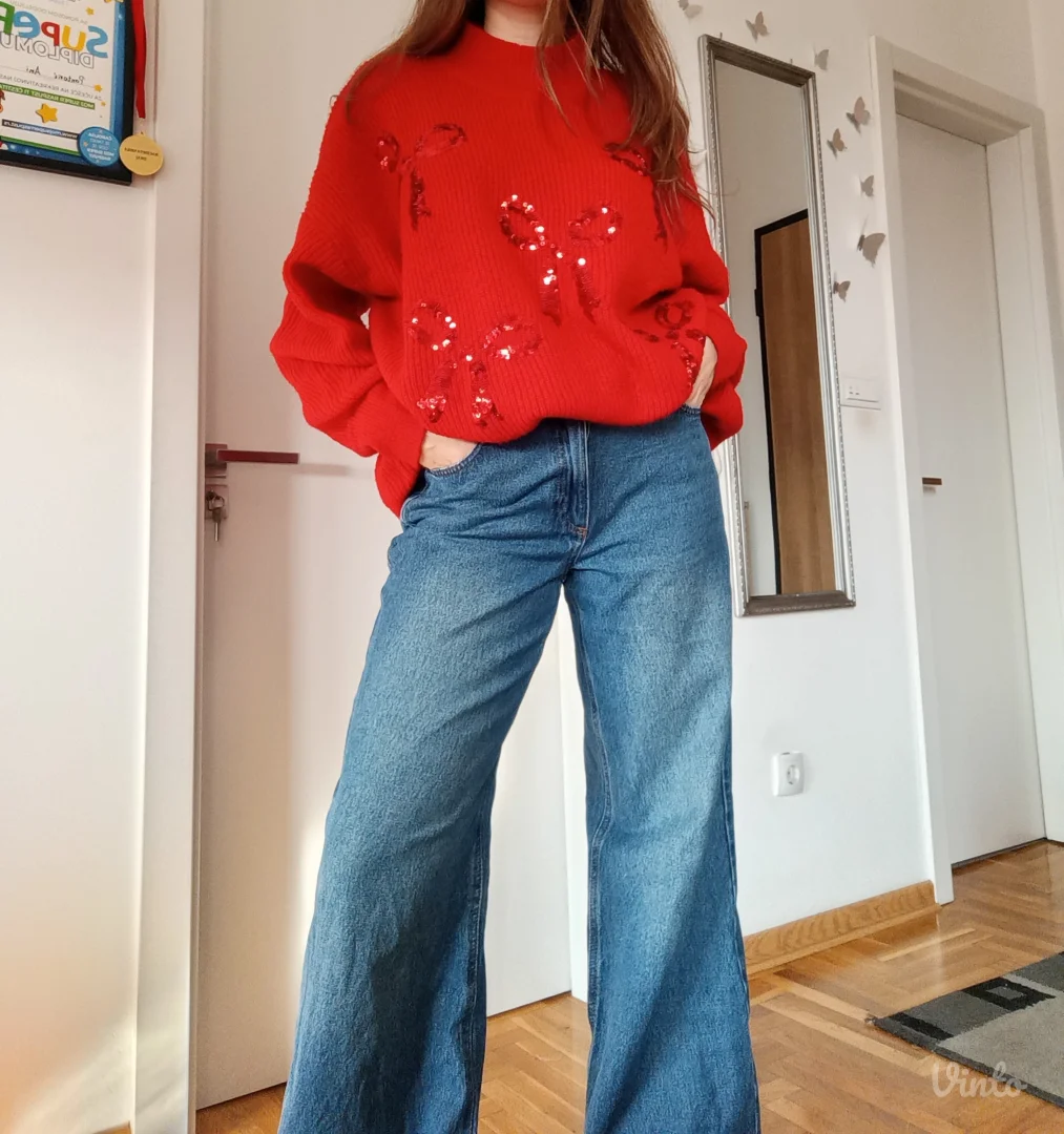 Crveni džemper sa mašnama po sebi