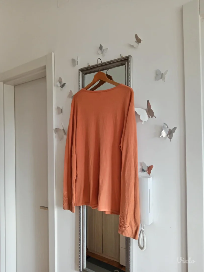 Narandžasti džemper sa radom po sebi