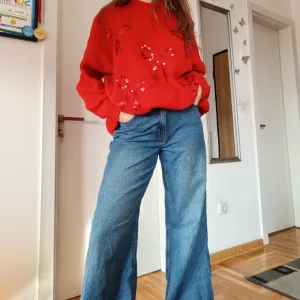 Crveni džemper sa mašnama po sebi