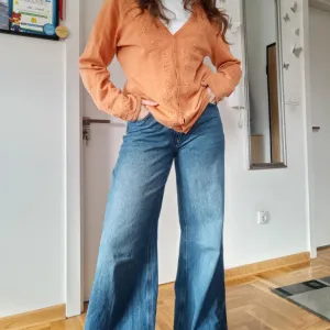 Narandžasti džemper sa radom po sebi