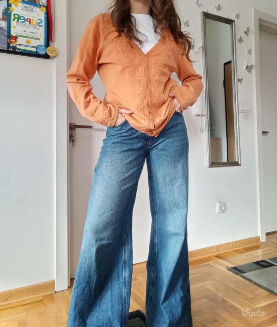 Narandžasti džemper sa radom po sebi