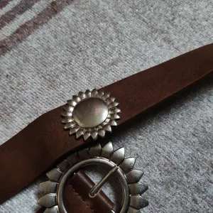 Braon kaiš sa dekorativnim metalnim detaljima