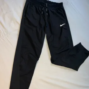 Crne NIKE pantalone sa reflektujućim znakom