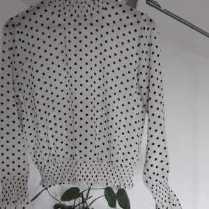 Bela lepršava košulja sa crnim tufnama sa širokim rukavima