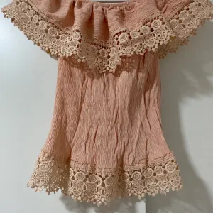 Majica sa cvetnim detaljima i golim ramenima