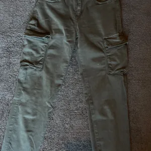 Maslinasto zelene ženske cargo pantalone – uske, lastiš na nogavicama