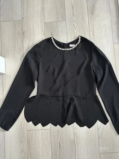 Elegantna crna bluza sa detaljem ogrlice i peplum krojem