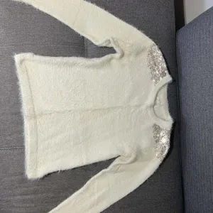 Springfield cupavi beli dzemper sa šljokicama