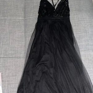 Elegantna crna haljina sa šljokicama i tilom