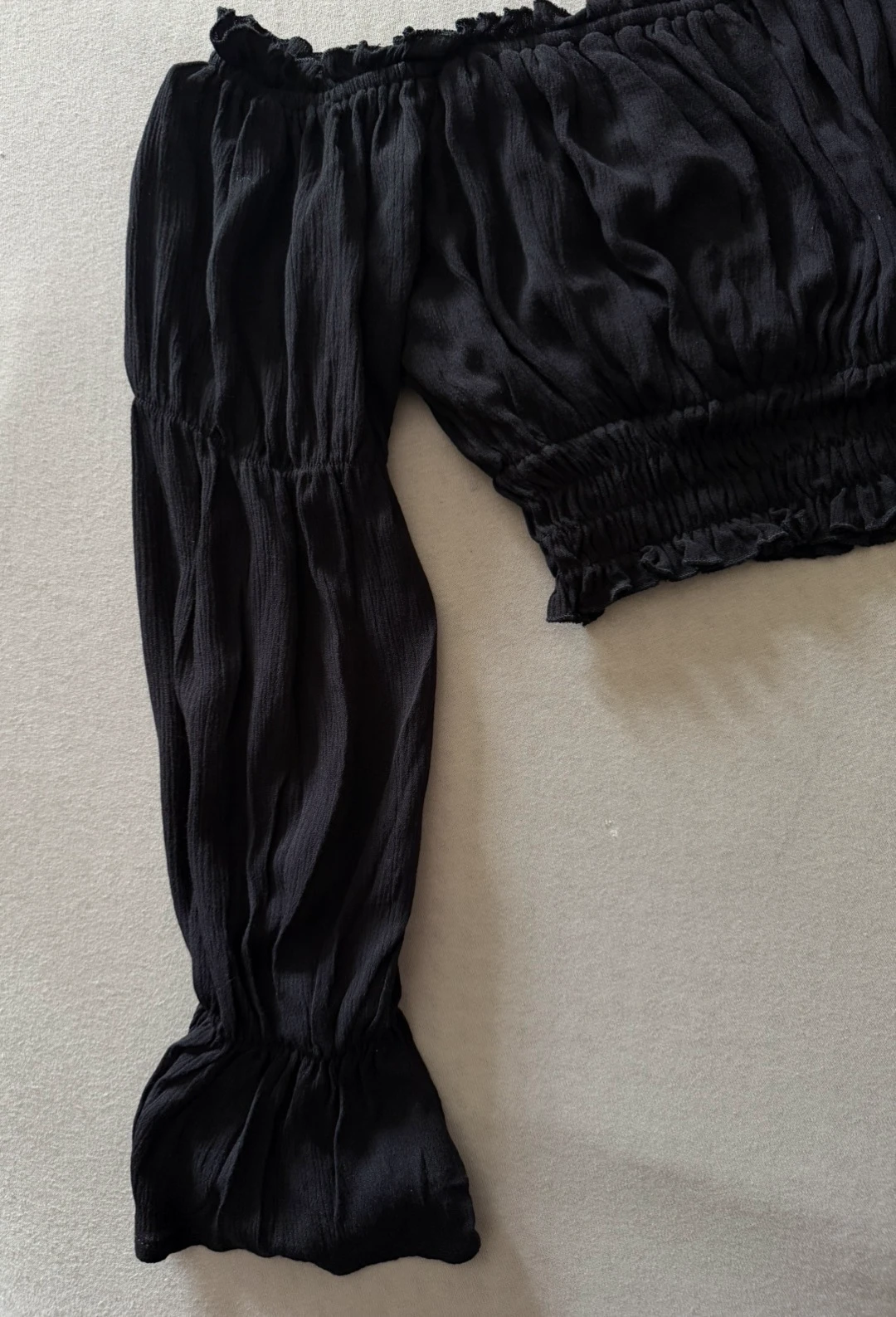 Crni off-shoulder crop top sa dugim rukavima