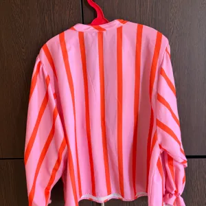 Roza košulja sa crvenim prugama