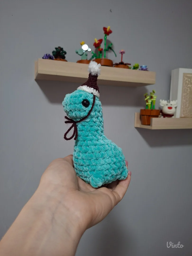 Ručno heklani dino sa božićnom kapicom