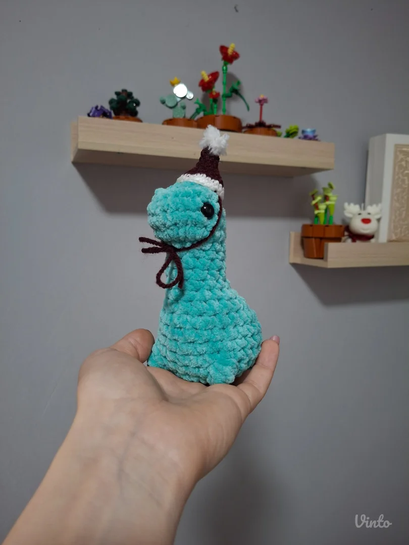 Ručno heklani dino sa božićnom kapicom