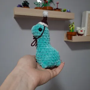 Ručno heklani dino sa božićnom kapicom